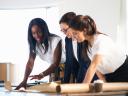 Photo showing a small business team of women setting up their minimum viable product on a tablet together.