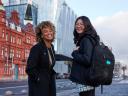 Two women smile at the camera in front of the Salesforce Dublin office.