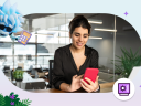 A woman sits at a desk in a financial services IT office using a red cell phone. The image is framed with a light blue and purple gradient frame featuring Agent Astro holding a calculator on the top left and a Salesforce Financial Services purple icon in the bottom right.