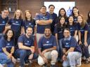 In the Salesforce Singapore office, a group of employees gather together wearing matching blue "volunteer" shirts