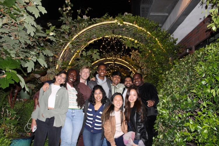 Rucha and her Associate Product Manager internship cohort under arches decorated in greenery