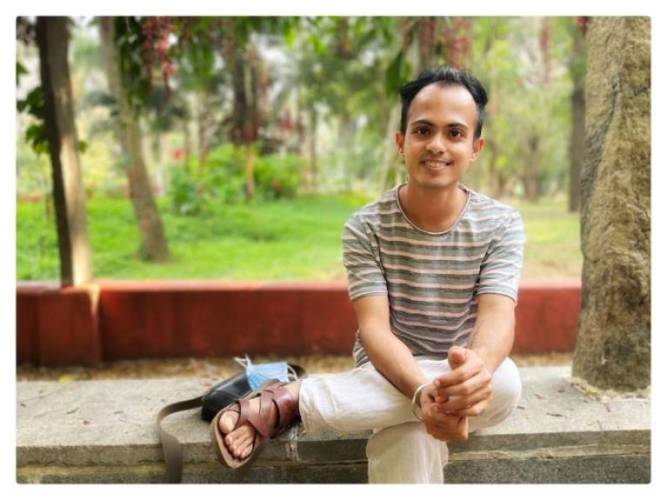 Sumit Paul sits on a concrete bench in a park.