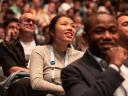 People smiling in the audience of a presentation at Dreamforce.