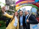Three attendees smile while taking a selfie together outdoors at Dreamforce.