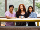 Three women, Salesforce employees smiling and are sharing some time together.