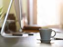 Morning light on desk computer and coffee cup.