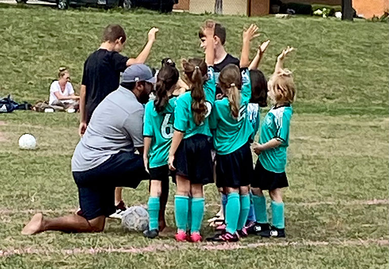 Vrahram talking to his daughter football team