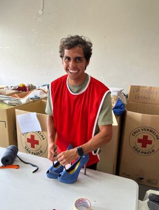 Pedro wearing a red vest and smiling