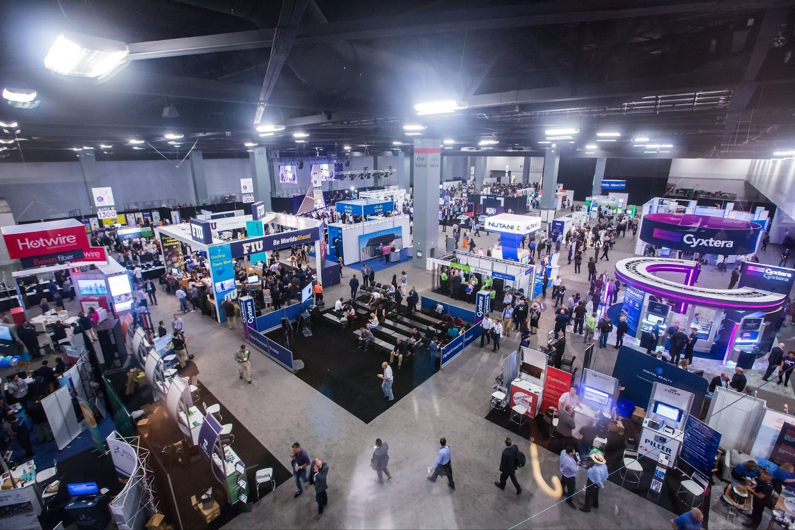 Crowds of attendees exploring booths and displays at the expo floor of the eMerge Americas show.
