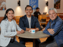 Three Salesforce employees spending time together in a cafeteria.