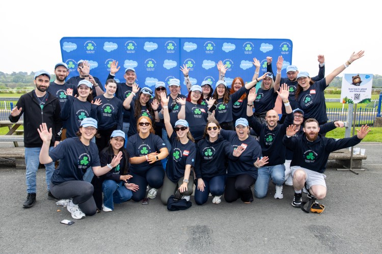 A group of smiling Salesforce employees posing together for a photo.