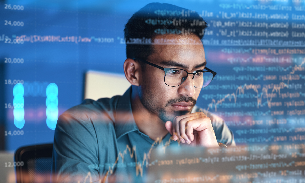 Man looking at computer screen with code and graphs as an overlay