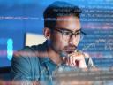 Man looking at computer screen with code and graphs as an overlay