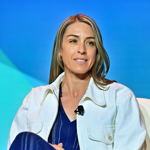 Chief Accessibility Officer at Salesforce, Catherine Nichols, wearing a blue jacket and jumpsuit, seated in front of a blue backdrop.