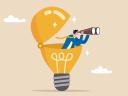 Person with binoculars in a light bulb icon representing looking forward