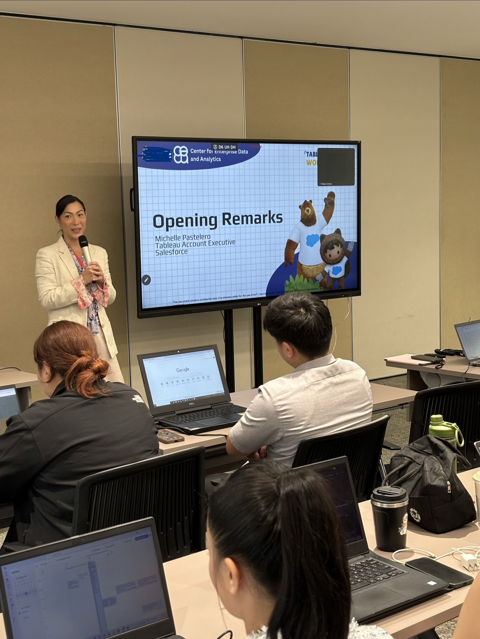 woman stands in front of group of people at a presentation