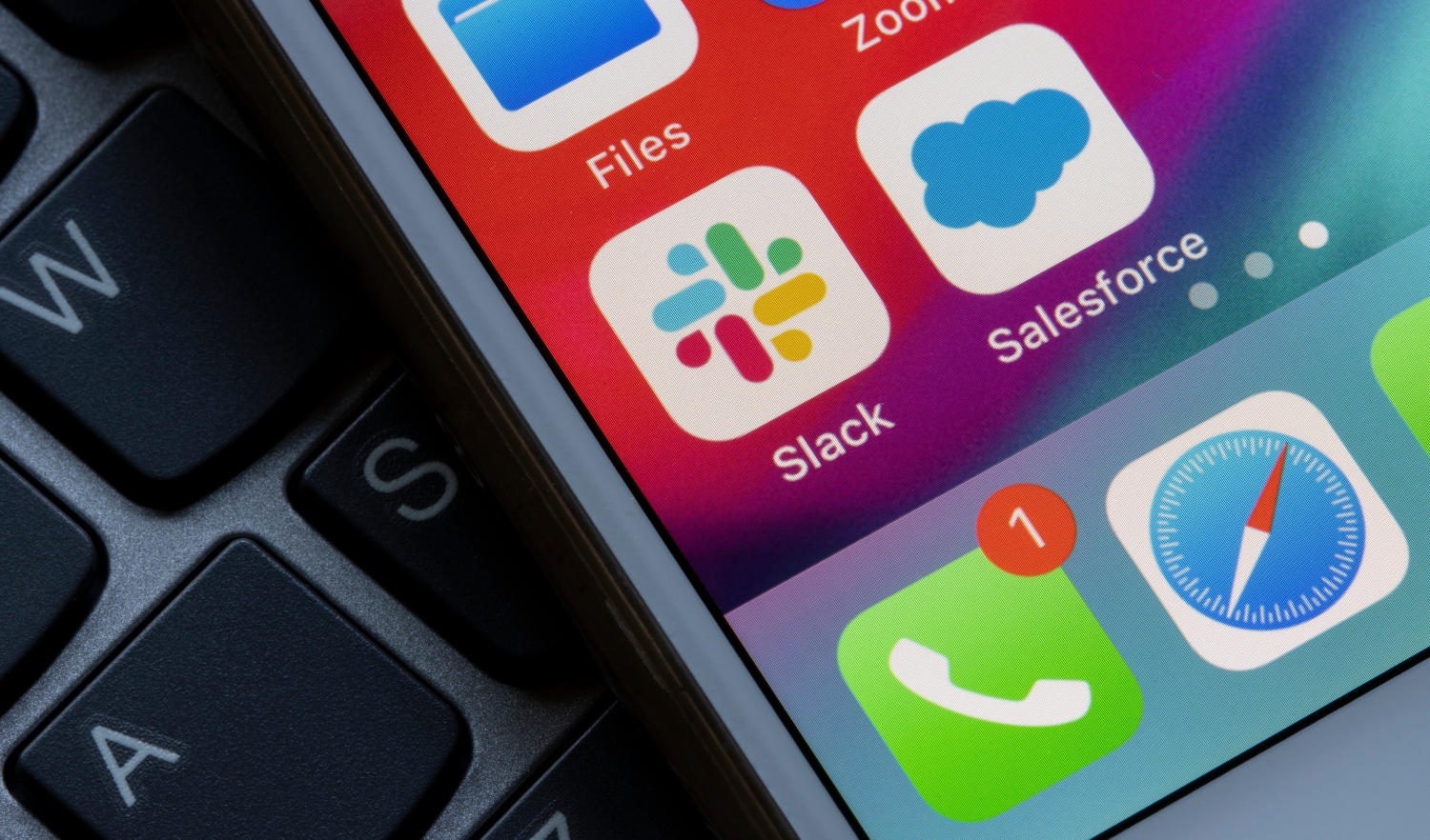 Slack and Salesforce app icons are seen on an iPhone screen.