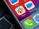 Slack and Salesforce app icons are seen on an iPhone screen.
