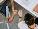 Excited call centre agents, fist bump and celebrating deal, promotion and sale from above in office.