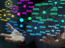 Colorful network diagrams floating above a pair of hands.