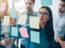 Team of people looking at whiteboard for agile methods.