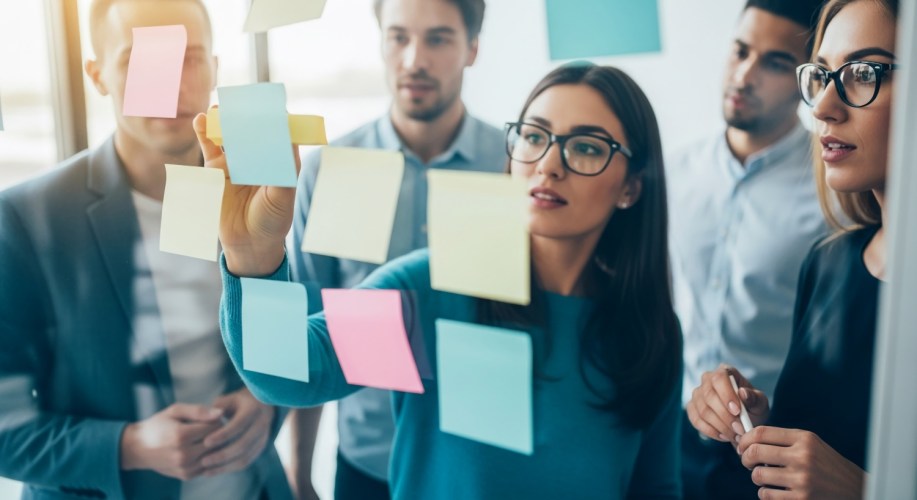 Team of people looking at whiteboard for agile methods.