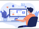 A young man sits at his desk, working on his computer. He is wearing glasses and a casual orange t-shirt. There are plants on the desk and the image is done in a flat design style.