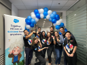group of employees pose by a balloon arch