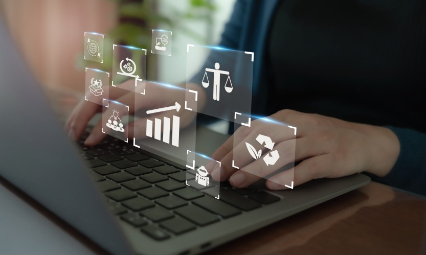 Person typing on laptop. Images of scales, graphs, an AI development overlayed.