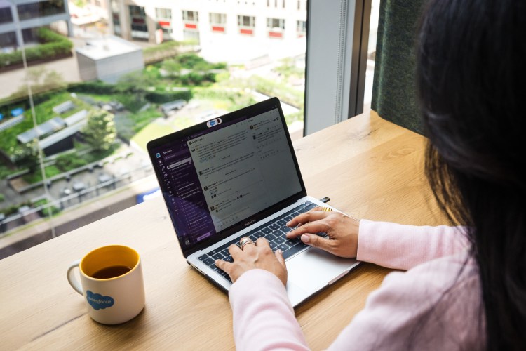Image of someone typing at a computer with Slack pulled up