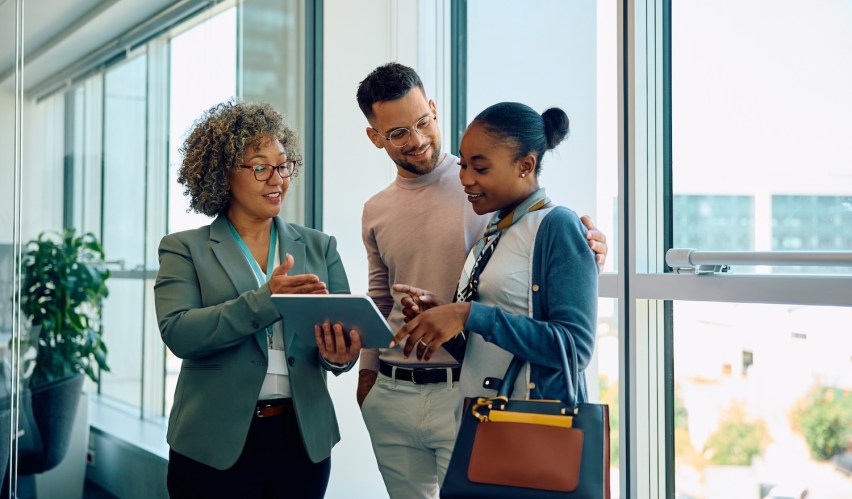 A professional financial advisor providing personalized, human-centric service to a couple, demonstrating how AI automation frees employees to build deep trust and genuine connection