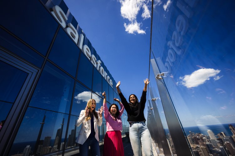 group of employees cheer outside of a salesforce office