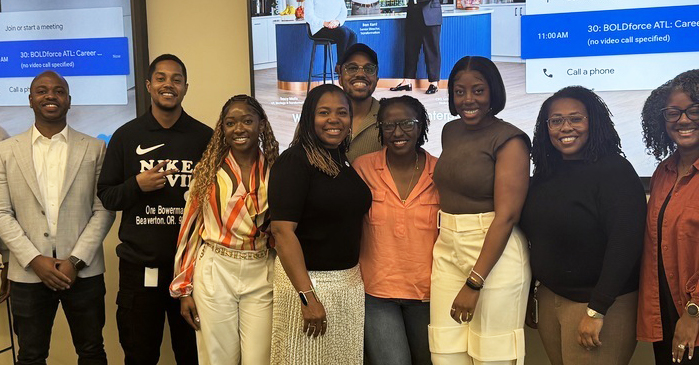 Group of nine people stand in a modern office space after an event