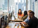 group of employees in the office collaborating over computers