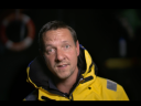 Andy Butterfield, Agentic AI GTM Lead at Salesforce, in a yellow reflective jacket speaking to the camera. It is nighttime.