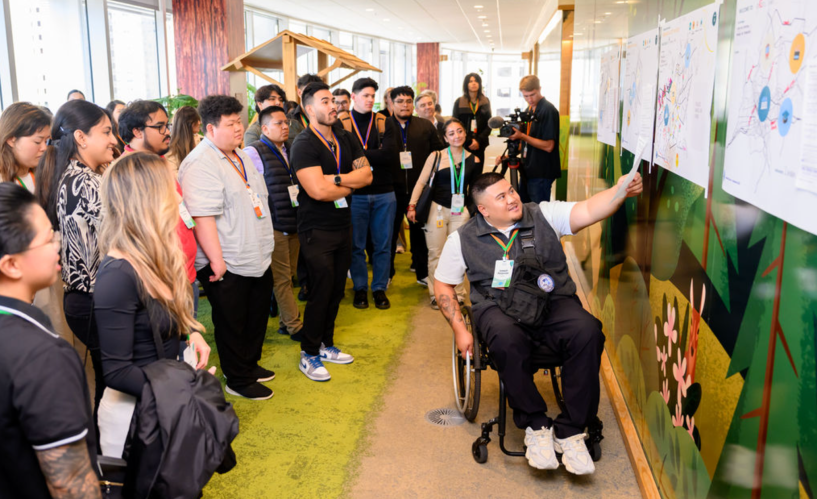 A mentor at Salesforce who is in a wheelchair presents to an audience of employees.