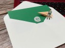 An oversized envelope with ampersand and arrow and SMB owner sitting on top of a desk, symbolizing email marketing.