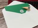 An oversized envelope with ampersand and arrow and SMB owner sitting on top of a desk, symbolizing email marketing.