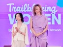 two women stand against a purple screen that reads "trailblazing women"
