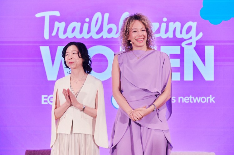 two women stand against a purple screen that reads "trailblazing women"