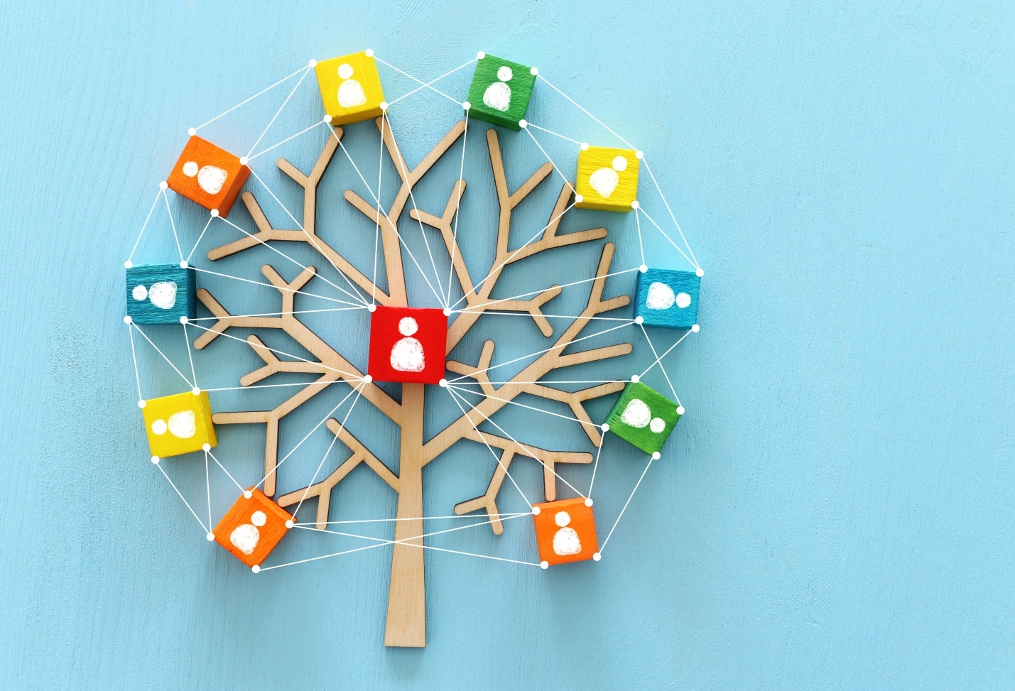 Illustration of a tree with branches leading to blocks with icons of team members on a blue background.