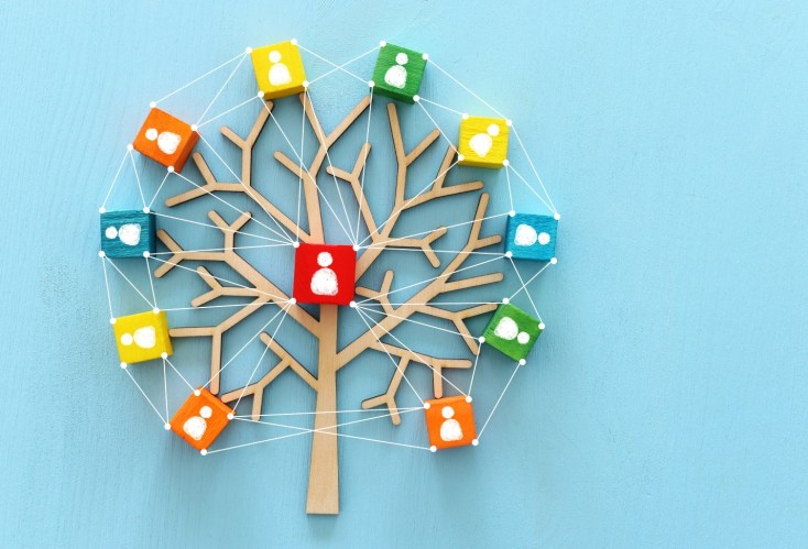 Illustration of a tree with branches leading to blocks with icons of team members on a blue background.