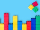 Bar graphs plastic building blocks toy bricks on blue background.