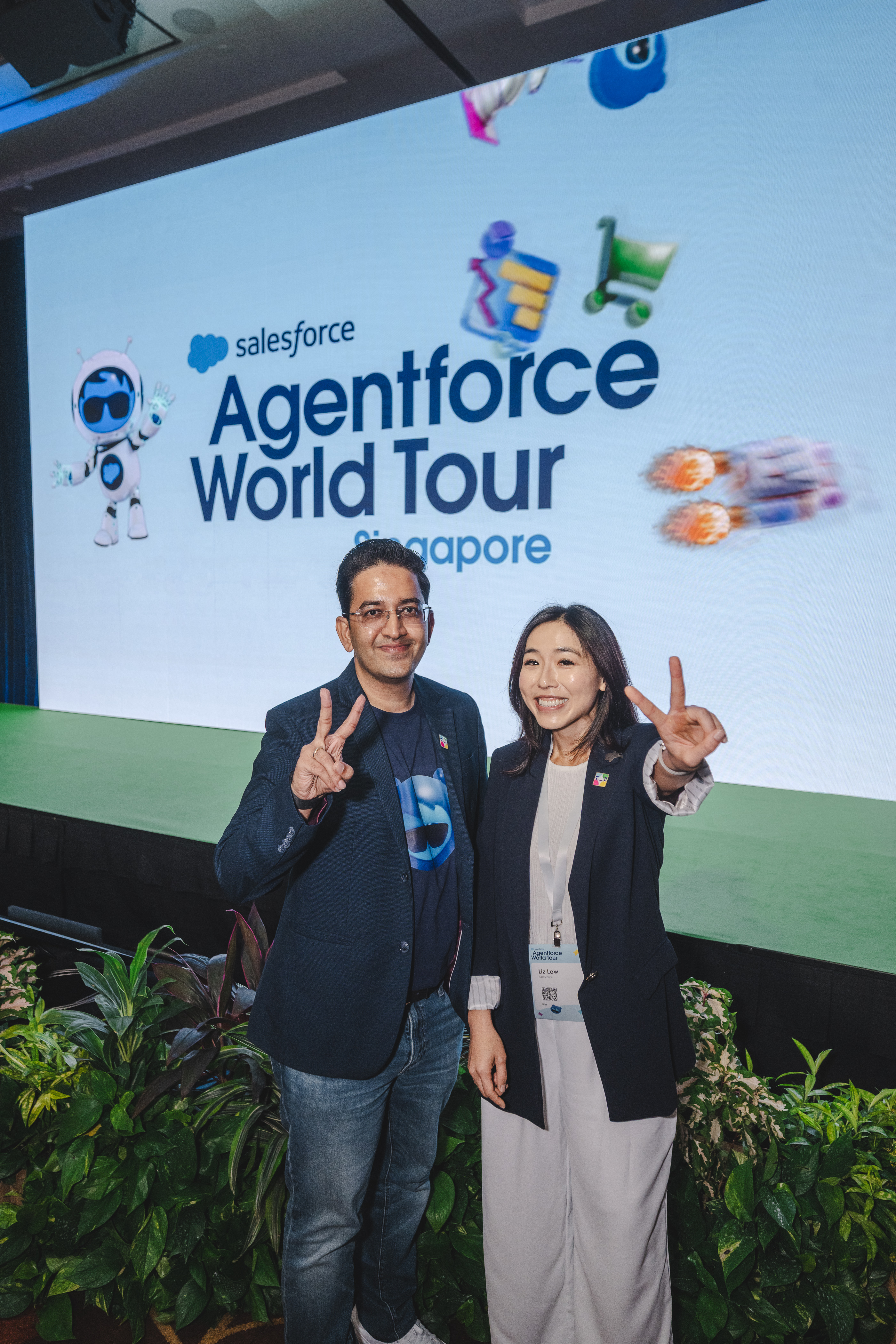 A man and a women in front of the Agentforce World Tour Singapore event stage.