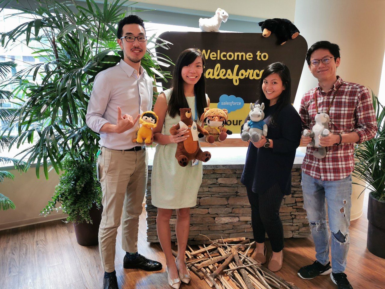 2 men and 2 women stand in front of a Welcome to Salesforce sign smiling