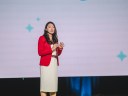 Woman in red blazer talking on stage