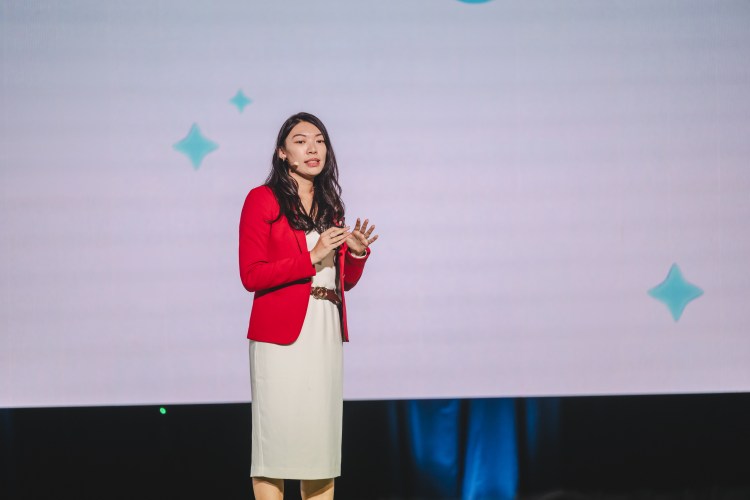 Woman in red blazer talking on stage