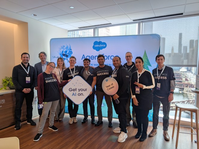 A group of people together holding Salesforce signs