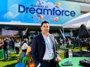 A man in front of a Dreamforce welcome sign