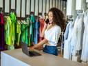 Smiling Latin designer contacts client about online order in fashion shop.